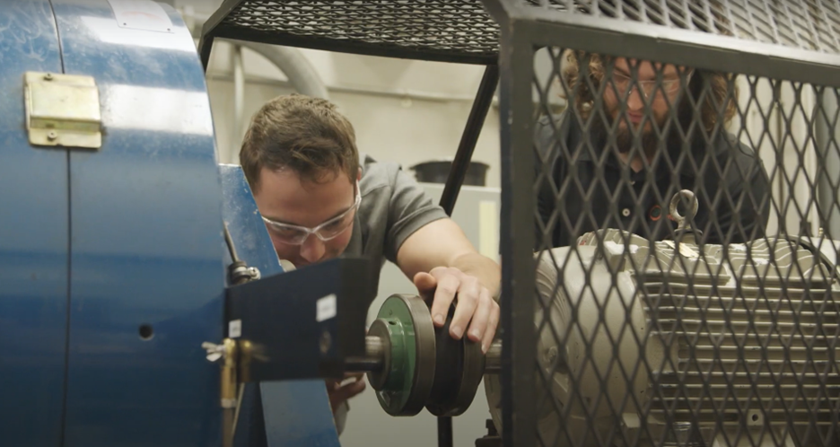 Man looking at an electric motor undergoing testing.