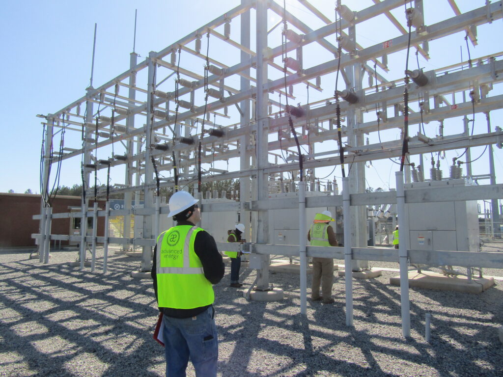 An engineer looking at a large piece of electrical equipment at the site of a renewable energy installation.