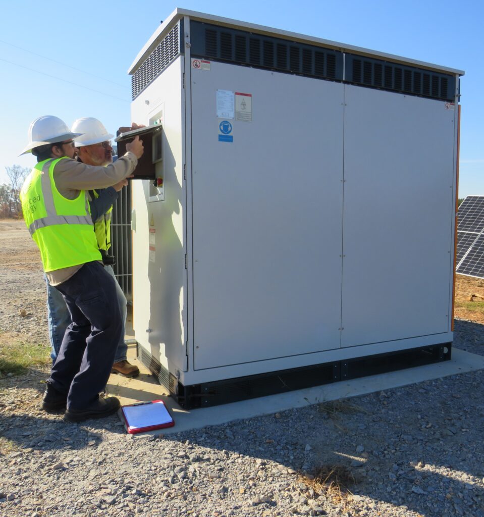 Engineers inspecting part of an inverter-based resource site for commissioning purposes.